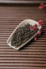 A Beautiful Presentation of Dried Tea Leaves on a Serving Dish Featuring Cherry Blossom Accents