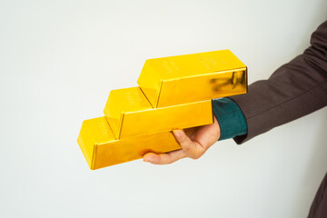Close-up of a businessman holding shiny gold bars, symbolizing wealth and investment, isolated on a...