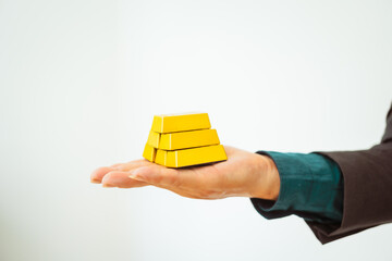 Close-up of a businessman holding shiny gold bars, symbolizing wealth and investment, isolated on a...