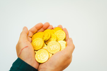 Close-up of a businessman holding shiny gold bars, symbolizing wealth and investment, isolated on a...