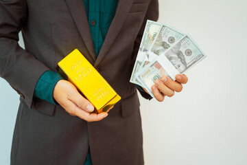 Close-up of a businessman holding shiny gold bars, symbolizing wealth and investment, isolated on a...