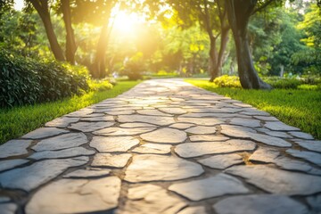 A stone path through a park, with sunlight streaming through the branches of trees, illuminating the path with a soft, golden hue.