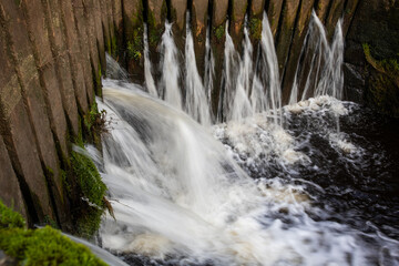 Fototapeta premium Water pouring through wooden canal lock gates