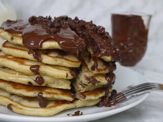 Pancake tower with chocolate chips and covered in melted chocolate