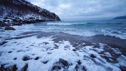 Fototapeta premium Winter Seascape Snow Covered Beach Ocean Waves Crashing on Rocky Shore