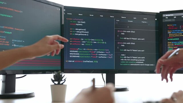 Slow motion back end software developer engineer for computer programming working together on debugging writing computing code, solving complex algorithms display on monitor in office. Burgeoning