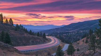 Sunset hues paint the sky as long-exposure light trails streak along a winding highway, symbolizing movement and transition.