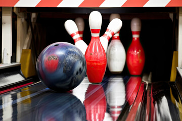 A bowling ball rolling down the lane, high-fiving pins as they fall