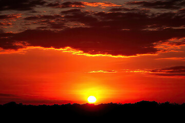Obraz premium Sunset sky with bold reds and oranges, fading into darker tones near the horizon