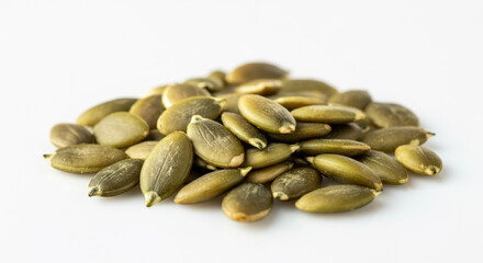 A heap of fresh pumpkin seeds in various shades of green placed on a plain white background