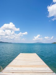 Fototapeta premium Lakeside wooden platform overlooking serene blue lake under clear sky with fluffy white clouds, wood floor, tranquil