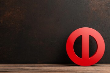 Fototapeta premium A bold red symbol rests on a wooden surface against a dark background, creating a striking visual contrast.