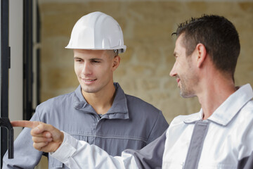two workers inspecting a door