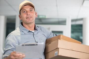 delivery man arriving at premises with clipboard