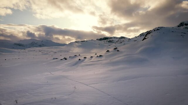 Soar above a snowy Norwegian winter wonderland! Stunning aerials capture majestic mountains, frozen lakes, and charming cabins bathed in golden sunlight. Push in side rotation 4k