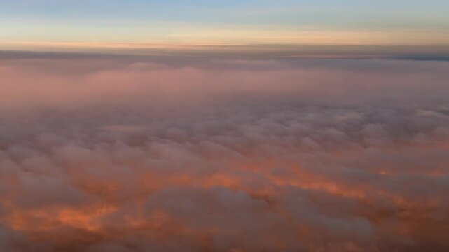 A pilot&rsquo;s POV FPV flying over golden color stratus clouds illuminated with the sunrise light recorded from a jet cokpit. An immersive perspective. 4K 60FPS
