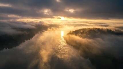 Fototapeta premium Stunning sunrise illuminating a foggy river landscape with serene reflections and soft light over tranquil waters.