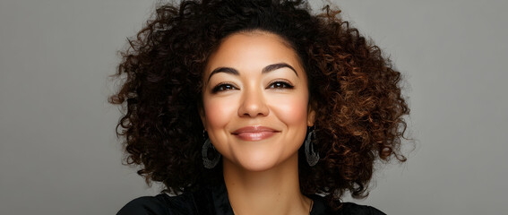 Candid portrait of a mixed-race woman with natural curls and a genuine, heartfelt smile