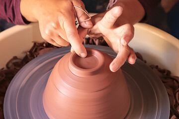 Hands Craft Pottery on a Spinning Wheel with Clay Trimmings 