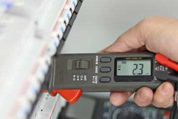 Measurement of electrical parameters in a switchboard using a multimeter. Soft focus. 