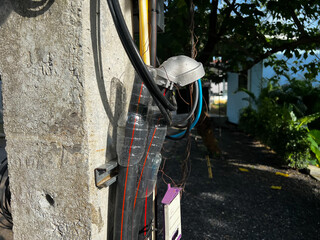 Water bottles used as makeshift electrical wire protection on a utility pole, showing improvised safety solution using discarded plastic bottles in Thailand