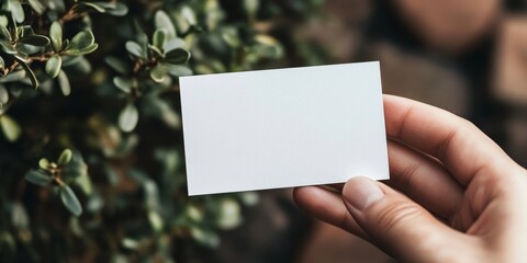 A hand is showcasing a white business card, indicating professionalism. This white business card represents a clean and minimalist design, perfect for various business settings.