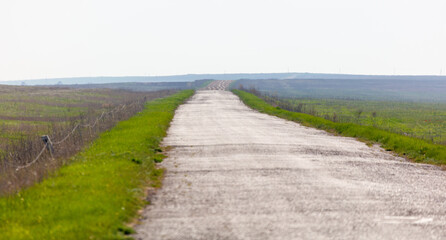 Fototapeta premium A long, empty road with a fence on the side