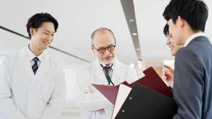 Fototapeta premium 話をする医者と営業職の男性