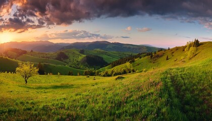 Obraz premium Beautiful mountain landscape with sunset and sunrise, green meadows, trees, and a peaceful countryside view