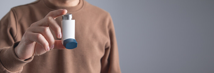 Caucasian man with a asthma inhaler. Concept of treatment of bronchial asthma