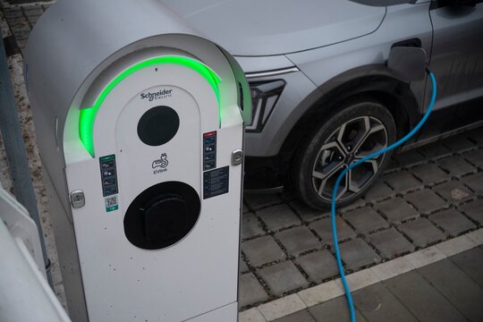 Grey kia niro ev charging at evlink by schneider electric station
