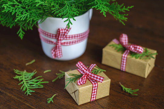 Close-up of wrapped Christmas gift boxes decorated with green juniper branches and ribbon