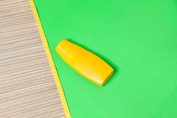 Jar of sunscreen with straw mat on green background. Sunscreen concept. Vacation concept. copy space.