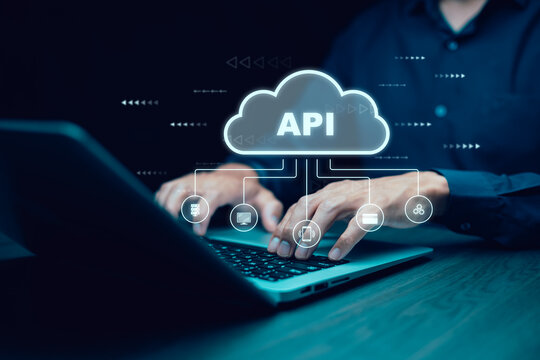 Businessman using laptop with API  icon on a virtual screen in the background of technology device internet, API Application Programming Interface connects services on the internet data communication.