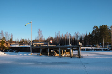 Snow-covered pier in Leksand, Dalarna showcasing winter beauty and serenity
