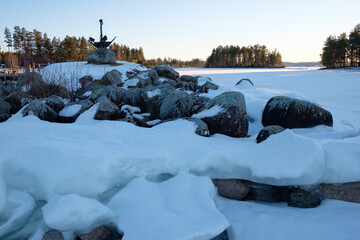 Winter landscape in Leksand, Dalarna, Sweden shows a snowy shoreline and frozen lake