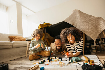 A joyful moment of a family creating a cozy fort, sharing play, and laughter.