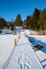 Winter landscape in Västanvik showcasing snow-covered dock and forested surroundings