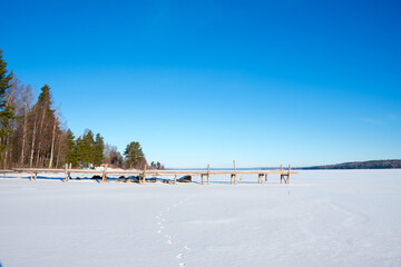 Snow-covered lake shore in Västanvik Dalarna Sweden during winter sunshine