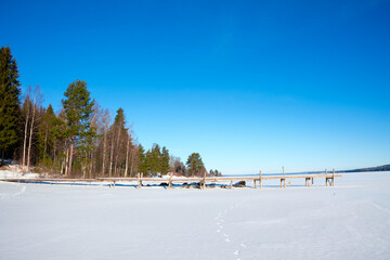 Winter landscape at Västanvik with snow-covered lake and wooden pier in Dalarna, Sweden