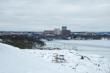 Winter view of Stockholm's frozen landscape and city skyline with snow-covered park