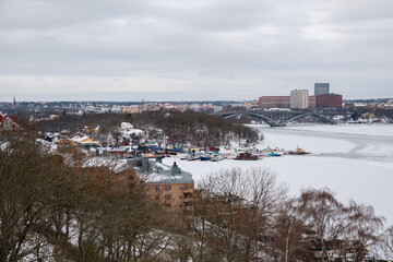 Winter landscape of Stockholm showcasing snow-covered waterfront and boats