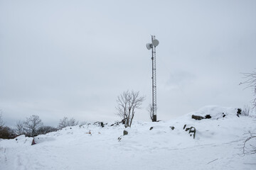 Winter landscape in Stockholm with snow-covered terrain and a communication tower