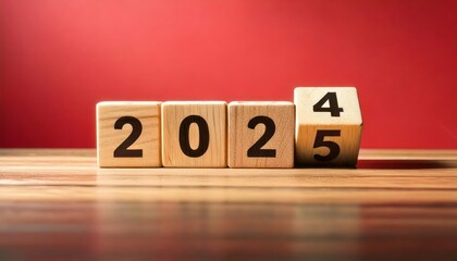 A wooden block display shows the year "2025" on a table against a red background.