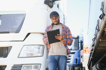 African American truck dispatcher inspecting a vehicle on a parking lot