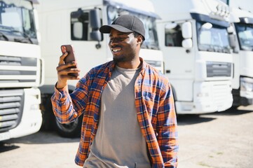 African American man having video communication on his smartphone while standing before lorry