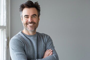 Fototapeta premium Portrait of a glad man in his 40s showing off a thermal merino wool top isolated in minimalist or empty room background