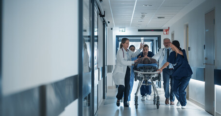 Emergency Medical Staff Moving an Injured Patient on a Stretcher Towards the Operating Room in a...