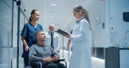 Obraz premium Portrait of a Female Medical Professional Engaging in a Thoughtful Conversation with a Disabled Patient in a Wheelchair, Using a Tablet to Highlight Key Information About His Care. Hospital Hallway