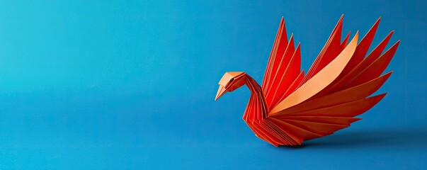 Colorful origami bird against a blue background, showcasing intricate craftsmanship and vibrant design.